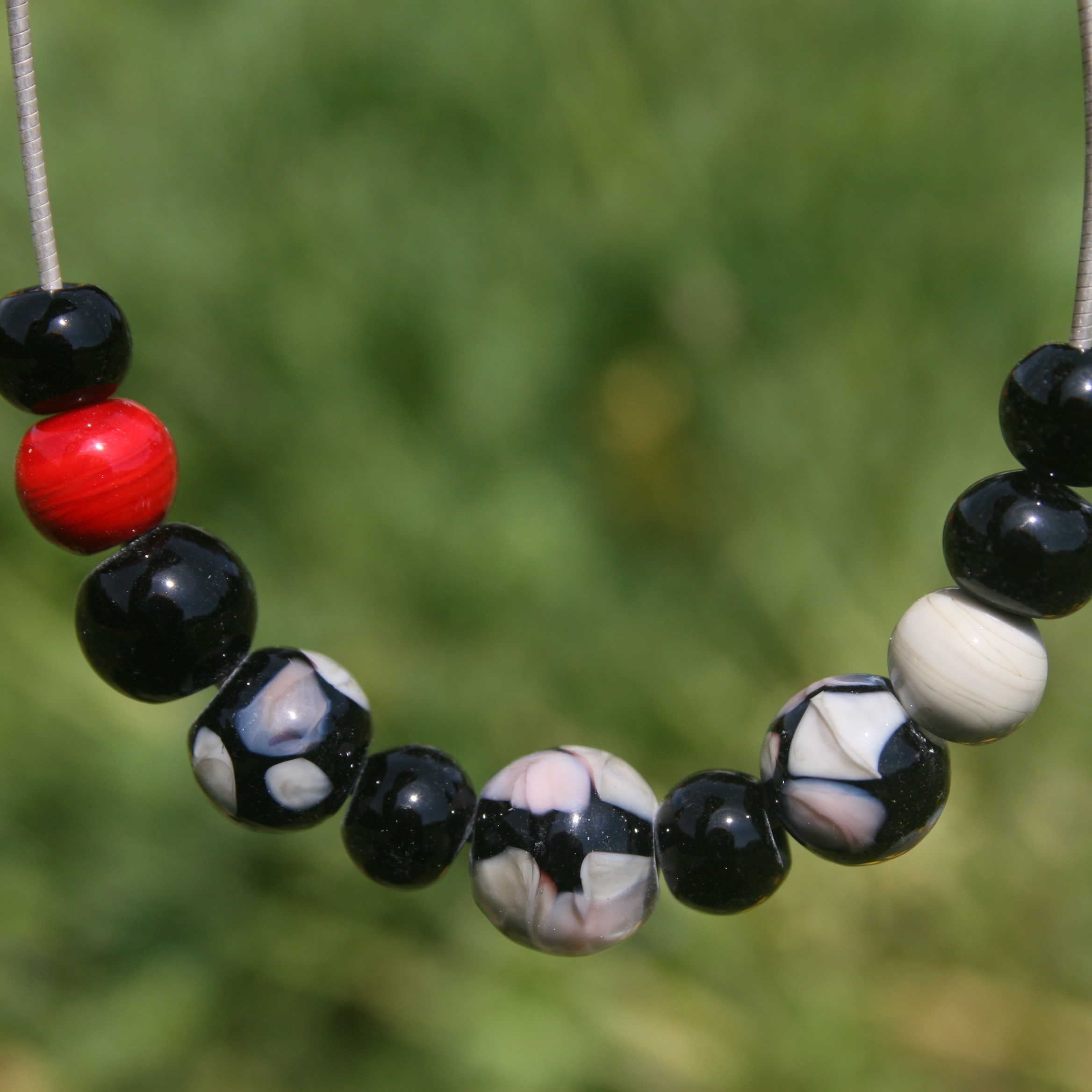 Collier en perles de verre de Murano noir beige et une perle rouge