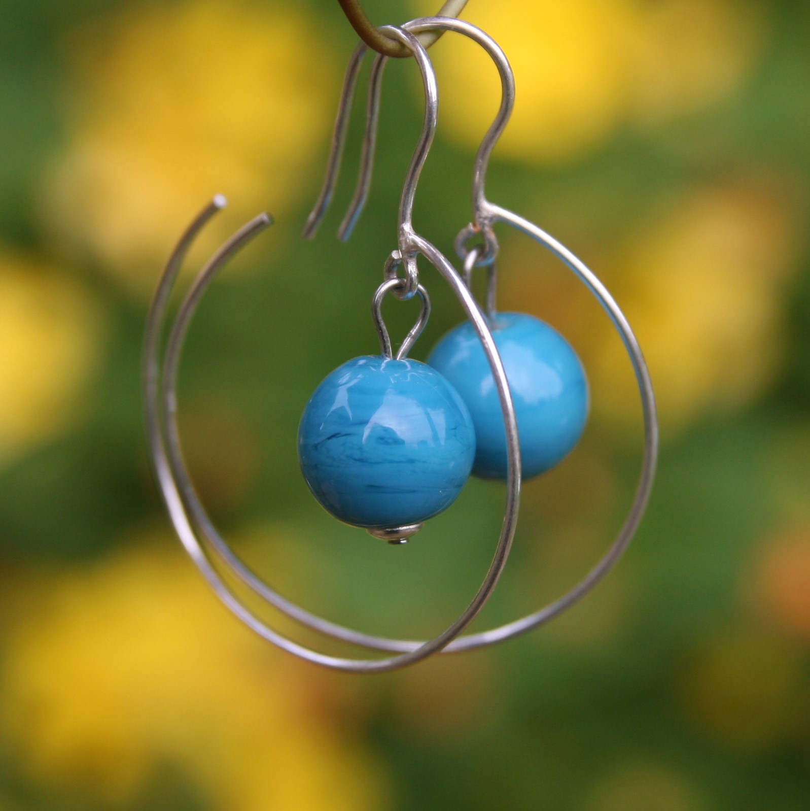 voici une paire de boucles d'oreilles creole en verre coloris turquoise