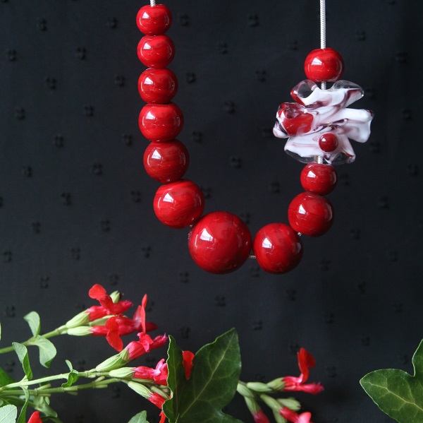 voici un collier en perles de verre artisanal de coloris rouge