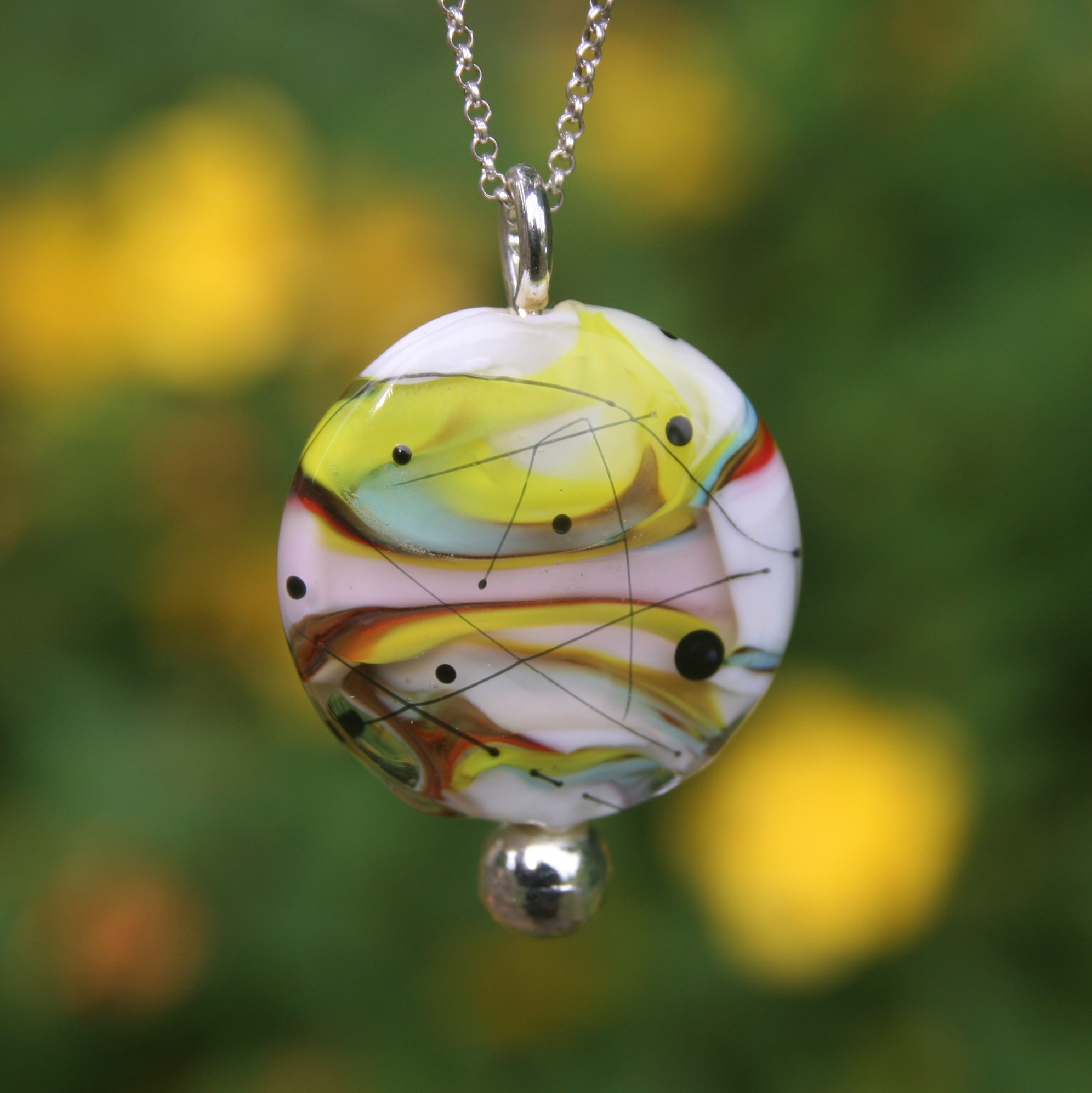 il s'agit d'un pendentif en perle de verre de Murano fond blanc et décor multicolore