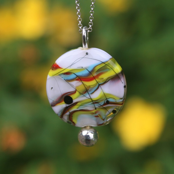 il s'agit d'un pendentif en perle de verre de Murano fond blanc et décor multicolore